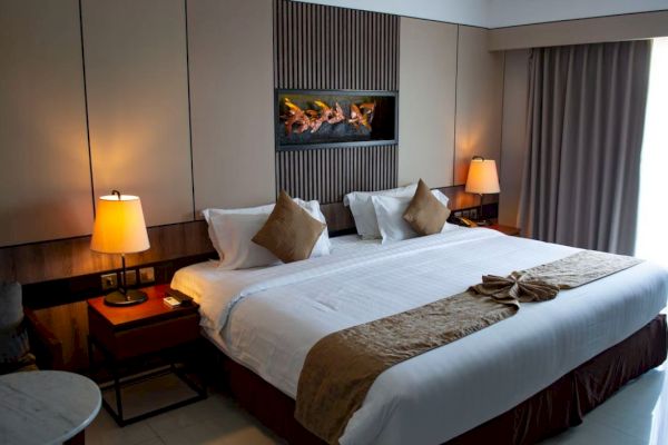A modern hotel room with a large bed, bedside lamps, a wall-mounted decoration, bedside tables, and a window with curtains ending the sentence.