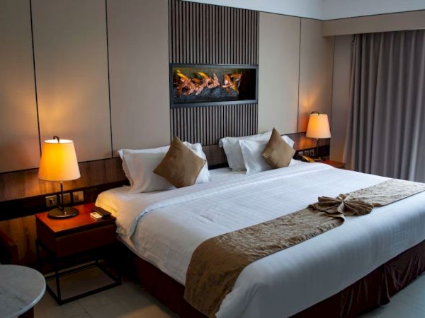 A modern hotel room with a large bed, bedside lamps, a wall-mounted decoration, bedside tables, and a window with curtains ending the sentence.