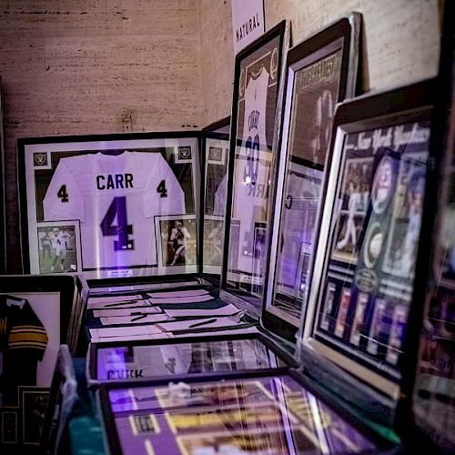 The image shows sports memorabilia, including a framed jersey with the name 