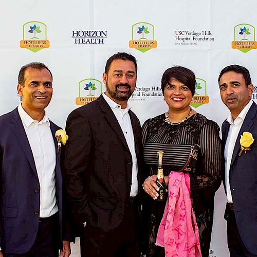 Four people dressed formally pose in front of a backdrop featuring Horizon Health and USC Verdugo Hills Hospital Foundation logos.