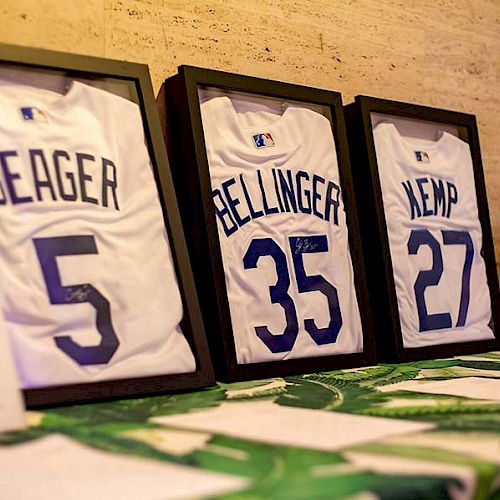 The image shows framed baseball jerseys with the names 