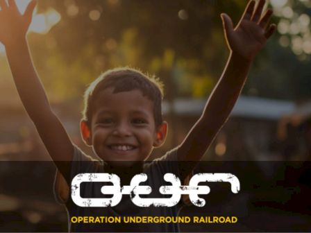 A smiling child raises their arms in joy. The text "Operation Underground Railroad" and logo are visible on the image.