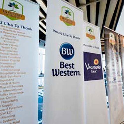 The image shows several banners displayed in a row. They list sponsors and thank them, featuring logos of Best Western and Vacation Inn.