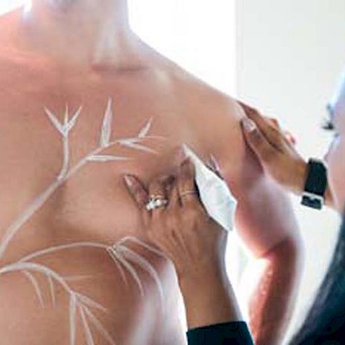 A person is drawing anatomical lines on the chest of another individual, likely for medical or educational purposes.